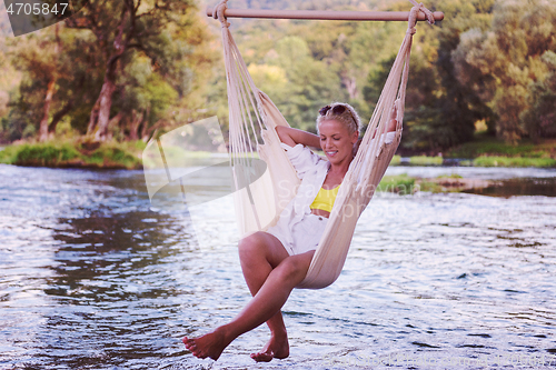 Image of blonde woman resting on hammock