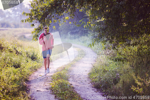 Image of man jogging along a country road
