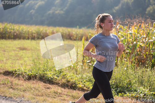 Image of woman jogging along a country road