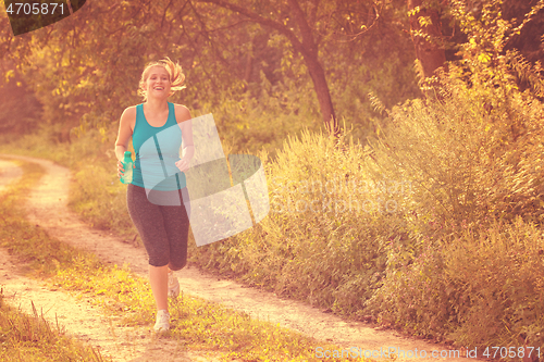 Image of woman jogging along a country road