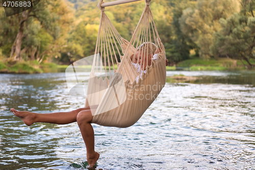 Image of blonde woman resting on hammock