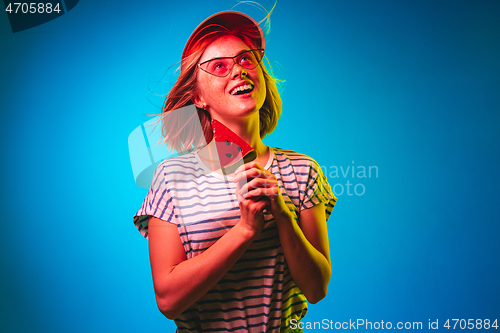 Image of Beautiful woman in neon light isolated on blue studio background