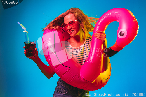 Image of Beautiful woman in neon light isolated on blue studio background