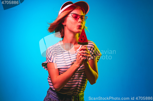 Image of Beautiful woman in neon light isolated on blue studio background