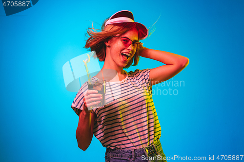 Image of Beautiful woman in neon light isolated on blue studio background