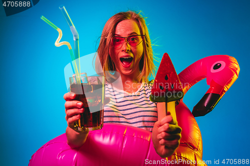 Image of Beautiful woman in neon light isolated on blue studio background