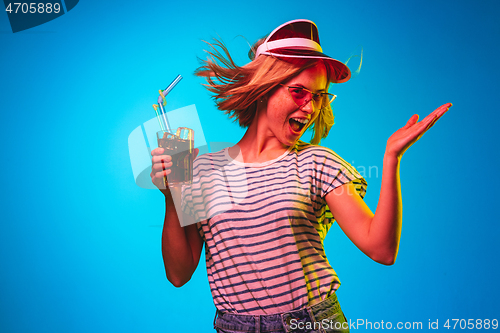 Image of Beautiful woman in neon light isolated on blue studio background