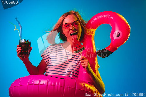 Image of Beautiful woman in neon light isolated on blue studio background