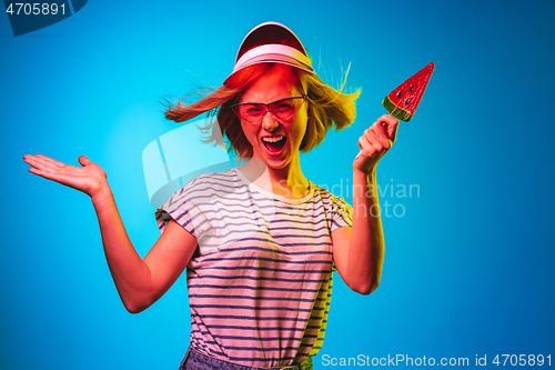 Image of Beautiful woman in neon light isolated on blue studio background