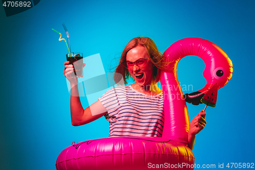 Image of Beautiful woman in neon light isolated on blue studio background