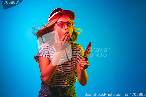 Image of Beautiful woman in neon light isolated on blue studio background