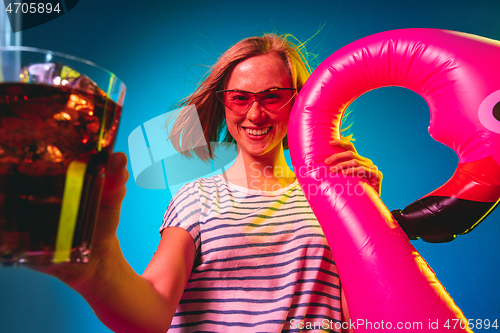 Image of Beautiful woman in neon light isolated on blue studio background