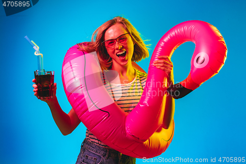 Image of Beautiful woman in neon light isolated on blue studio background