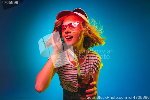 Image of Beautiful woman in neon light isolated on blue studio background