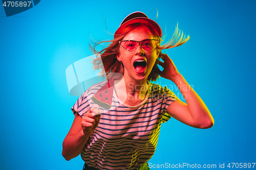 Image of Beautiful woman in neon light isolated on blue studio background