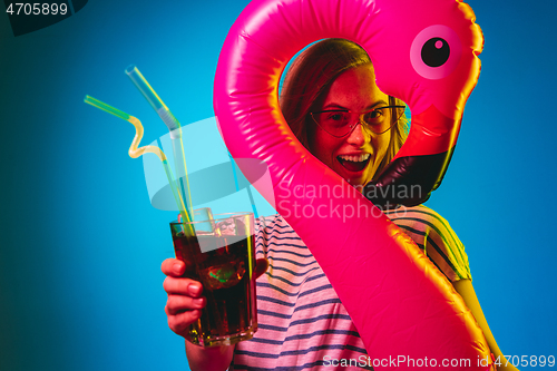 Image of Beautiful woman in neon light isolated on blue studio background