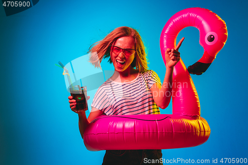 Image of Beautiful woman in neon light isolated on blue studio background