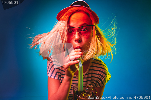 Image of Beautiful woman in neon light isolated on blue studio background