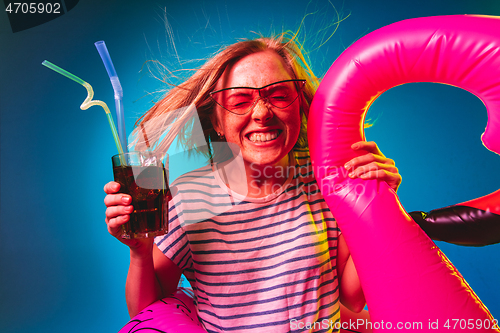 Image of Beautiful woman in neon light isolated on blue studio background