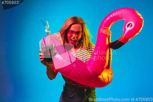 Image of Beautiful woman in neon light isolated on blue studio background