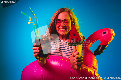 Image of Beautiful woman in neon light isolated on blue studio background