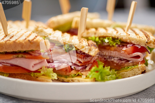 Image of Close up on appetizing fresh and healthy grilled club sandwiches with ham and cheese