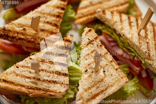 Image of Close up on appetizing fresh and healthy grilled club sandwiches with ham and cheese