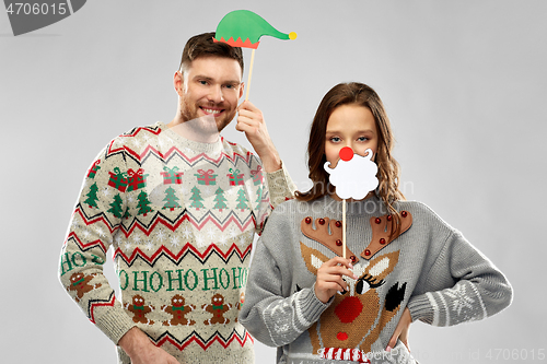 Image of couple with christmas party props in ugly sweaters