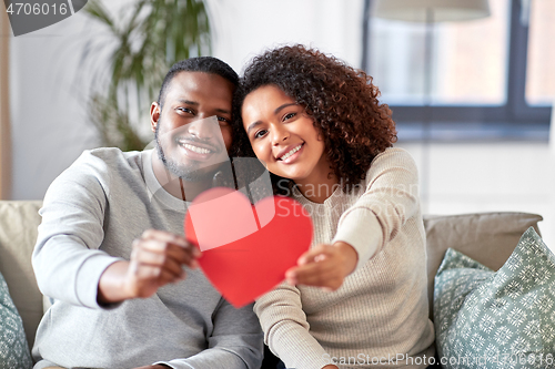 Image of happy african american couple with heart at home