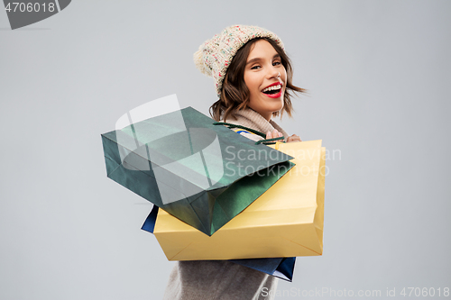 Image of young woman in winter hat with shopping bags