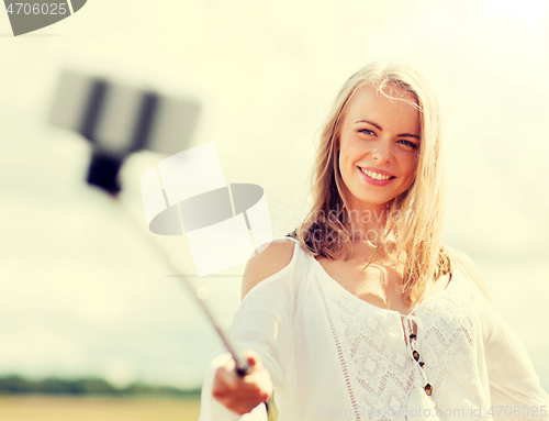 Image of happy young woman taking selfie by smartphone