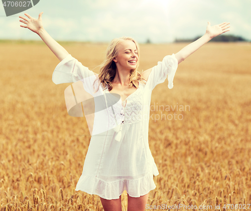 Image of smiling young woman in white dress on cereal field