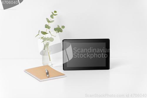 Image of tablet pc with black screen on white office table