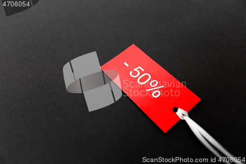 Image of red tags with discount signs on black background