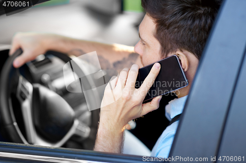 Image of man driving car and calling on smartphone