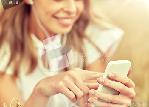 Image of close up of woman with smartphone and earphones
