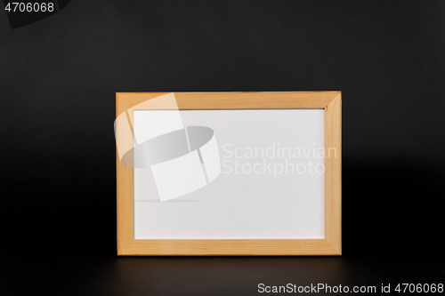 Image of white board in wooden frame on black background