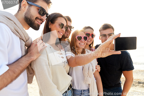 Image of happy friends taking selfie in summer