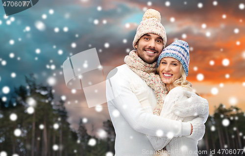 Image of smiling couple in winter clothes hugging