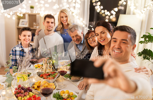 Image of family having dinner party and taking selfie