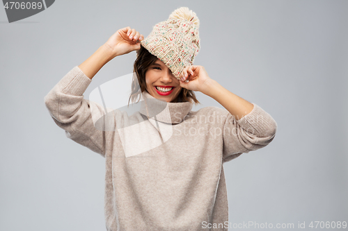 Image of young woman in knitted winter hat and sweater