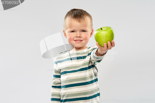 Image of portrait of smiling boy holding green apple