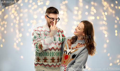 Image of happy couple at christmas ugly sweater party