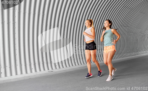 Image of young women or female friends running outdoors