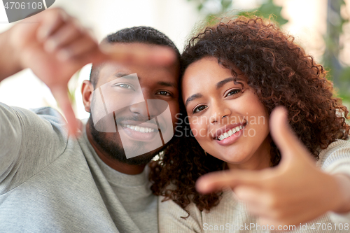 Image of happy couple making selfie gesture at home