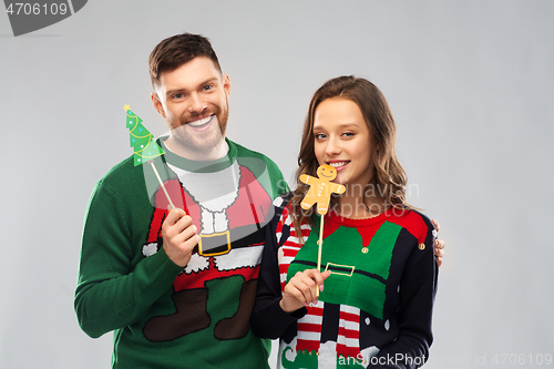 Image of couple with christmas party props in ugly sweaters