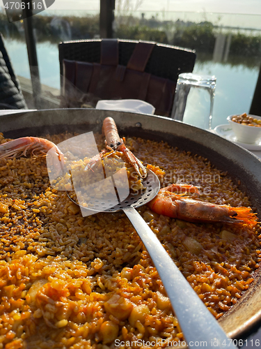 Image of Delicious traditional paella served in El Palmar, Spain