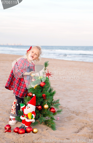 Image of Christmas portrait of a toddler girl on the sea shore