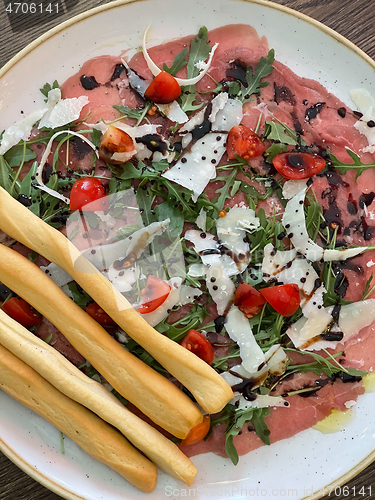 Image of Salad with jamon served with breadsticks