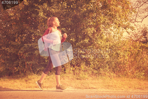 Image of woman jogging along a country road